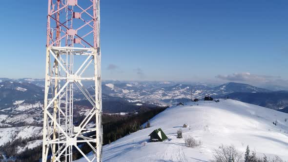 Flying Over Radio Communications Tower, Mountain Snow Covered Winter Landscape.