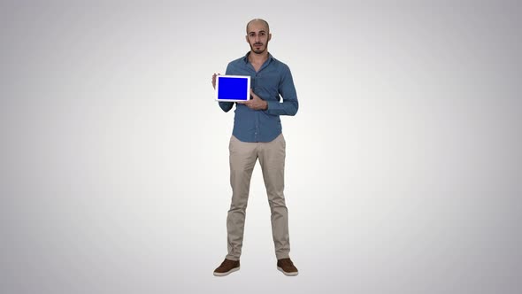 Arab Man Showing Blank Tablet Screen on Gradient Background.