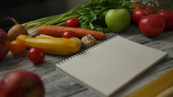 Blank Notepad for Recipe Amidst Vegan Food on Table