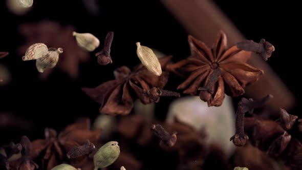 Super Slow Motion Shot of Flying Tea Mix Spices in Black Background