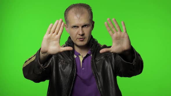 Rocker Man Showing Stop Gesture with Hands, No, Never, Disliking and Rejecting Sign, Chroma Key