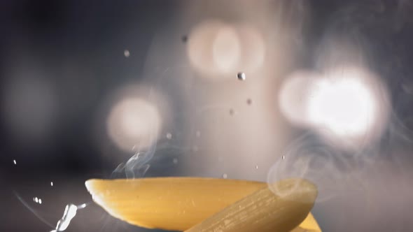 Pasta Penne is Flying Up on a Kitchen Bokeh Background