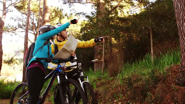 Mountain biking couple looking at map