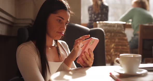 Beautiful Woman Using Smartphone in Cafe