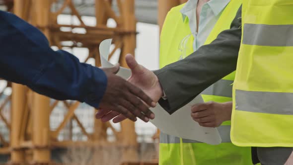 Unrecognizable Construction Site Workers Shaking Hands