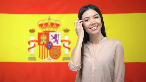 Beautiful Woman Looking at Camera Against Spanish Flag Background, Tourism