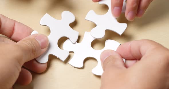 Teamwork, concept, completing white puzzle together