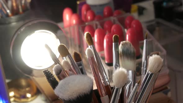 Various Makeup Brushes in a Special Glass on the Table in a Beauty Salon