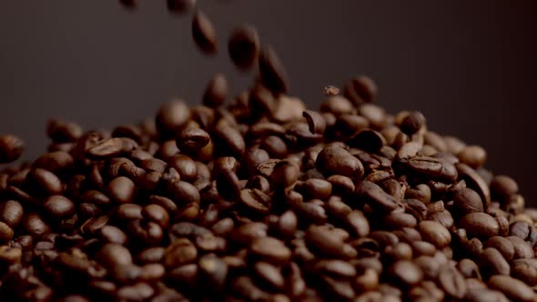 Fresh Coffee Grains Spilling on Pile Close Up