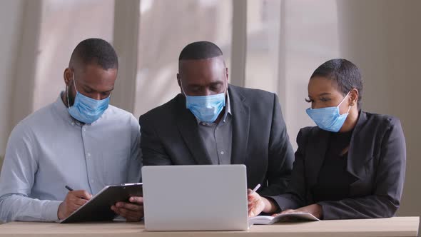 Diverse Afro Black Business Team in Protective Medical Face Masks Working in Modern Office