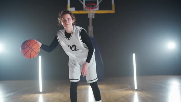 Portrait of Female Basketball Player Hits the Ball Off the Floor and Warms Up Before the Game