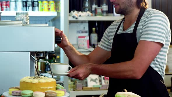 Male waiter holding a cup of coffee