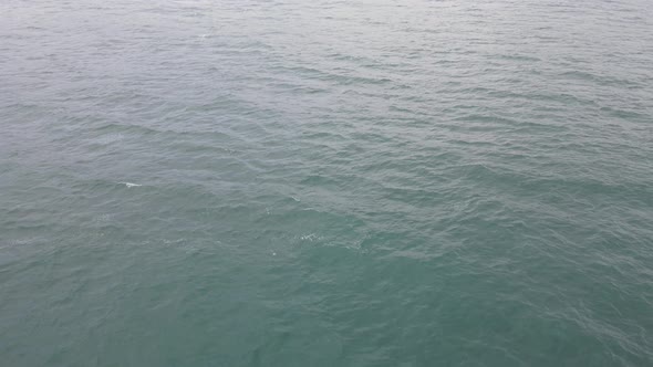 Top down aerial view of giant ocean waves crashing and foaming