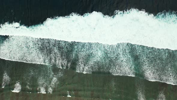 Waves crashing into the beach in shelves captured from the air in the beautiful remote holiday locat