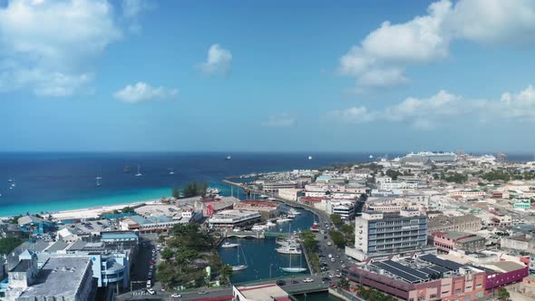 Air drone moves over Bridgetown, Barbados on sunny day. On the horizon the sea turns into the sky