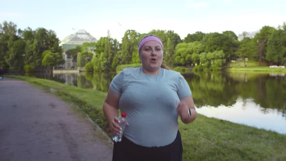 Obese Young Woman Jogging Outdoors in Summer Park Losing Weight