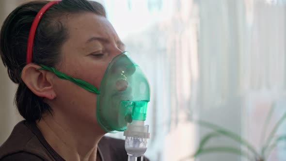 A European Woman at Home Carries Out Inhalation Inhalation of Oil Vapors Oxygen Through a Mask