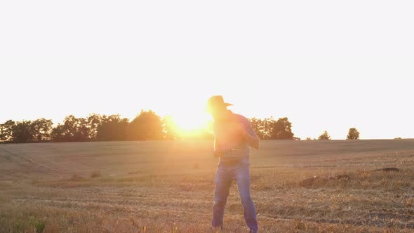 Happy Village Worker Dancing in a Field at Sunset