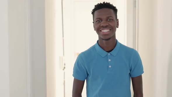 Young Man with Cheerfull Smile Posing on White Interior Background.