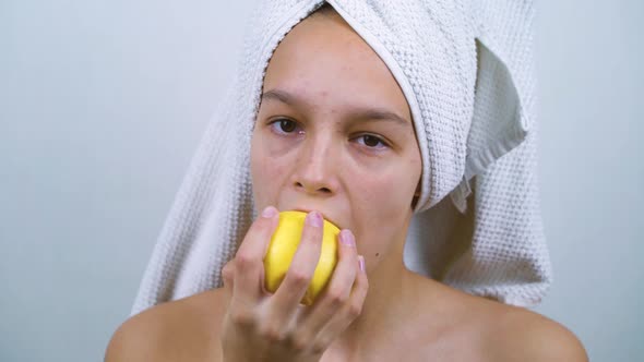 Puberty girl with bath towel on head having healthy snack
