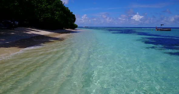 Luxury flying copy space shot of a white sandy paradise beach and blue ocean background in hi res 4K