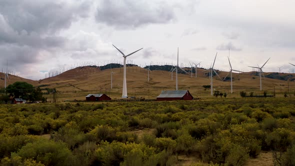 Red barn on a cloudy day with windmills