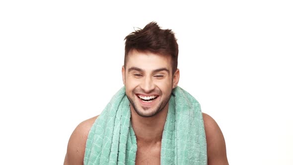 Handsome Caucasian Topless Male with Light Bristle Standing on White Background with Towel Around