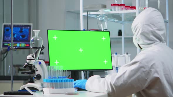 Doctor with Coverall Working at Computer with Green Screen