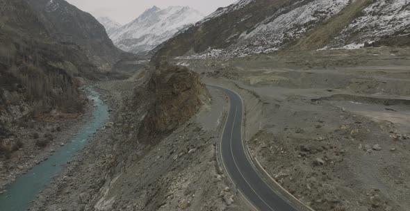 Amazing scenic windy road with mountains and glacier lake, aerial view. Attabad Lake is a lake locat