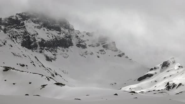 Little Avalanches are Falling in High Altitude Rocky Snowy Mountain Ridge