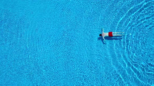 View From the Top As a Man Swims Under the Water in Pool