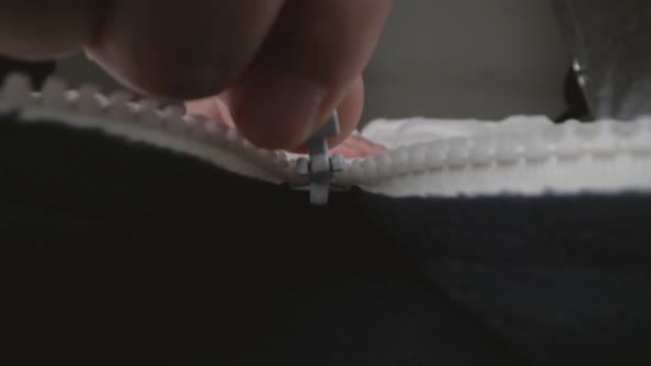 Extreme Close Up Zipper with Hand Unzipping the Sweater Jacket Zipper