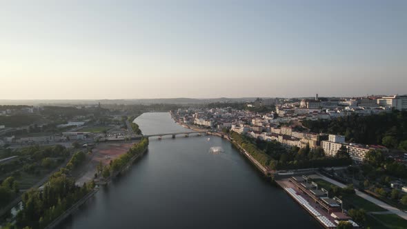 Mondego river and scenic view of Coimbra riverside. Aerial pullback
