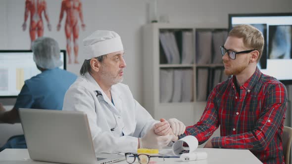 Mature Practitioner Examining Patient During Appointment