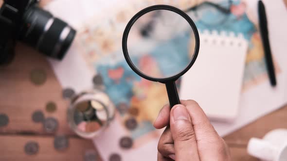 Young Man Using Magnifying Glass Looking Something on Map