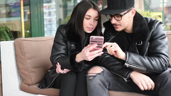 Young beautiful couple outdoor in the city using smart phone