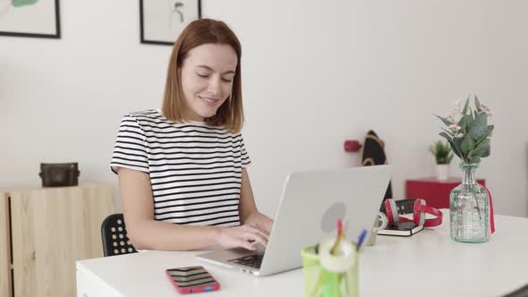 Beautiful Young Woman Working on Laptop Computer From Home