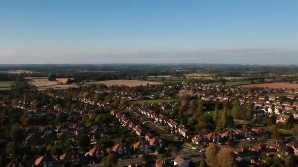 Ariel view of countryside in Warwickshire, England with green and yellow fields, trees and houses on