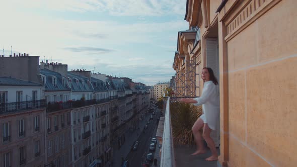 Beautiful girl in a white shirt on the balcony