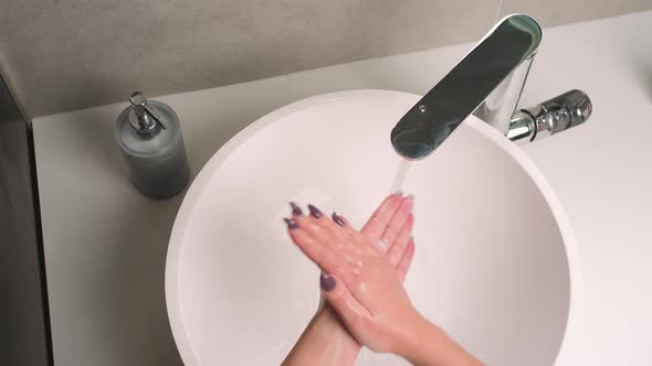 Close Up Woman Washes Her Hands with Soap at Home in the Bathroom