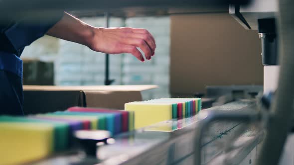 Factory Worker Placing Sponges Onto a Conveyor