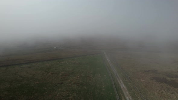 Moody North York misty rural moorland scene aerial view following vehicle on countryside road