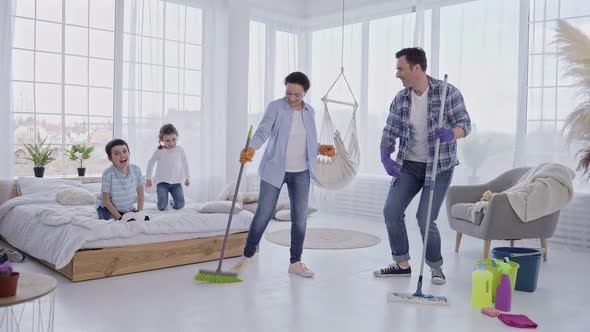 Joyful Couple Having Fun During House Cleaning