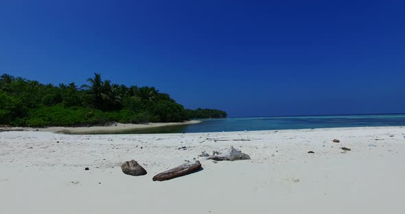 Wide above abstract shot of a sandy white paradise beach and turquoise sea background in 4K