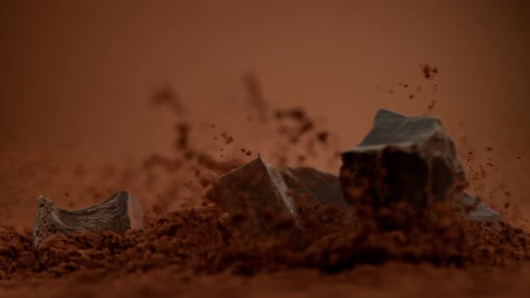 Super Slow Motion Shot of Raw Chocolate Chunks Falling Into Cocoa Powder at 1000Fps