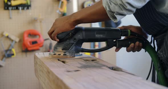 Carpenter polishing wood with machine 4k