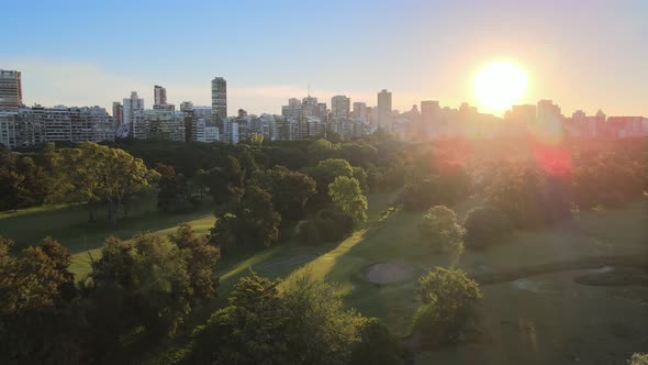 Aerial dolly right of Municipal golf course in Palermo neighborhood with buildings in background at