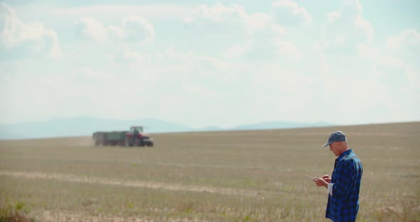 Farmer Using Digital Tablet While Examining Field