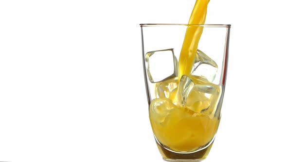 Super Slow Motion Shot of Pouring Fresh Orange Juice Into Glass with Ice Cubes at 1000 Fps