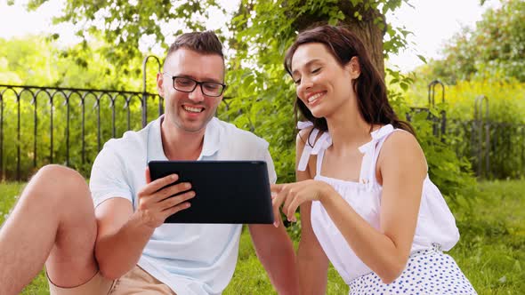 Happy Couple with Tablet Pc at Summer Park